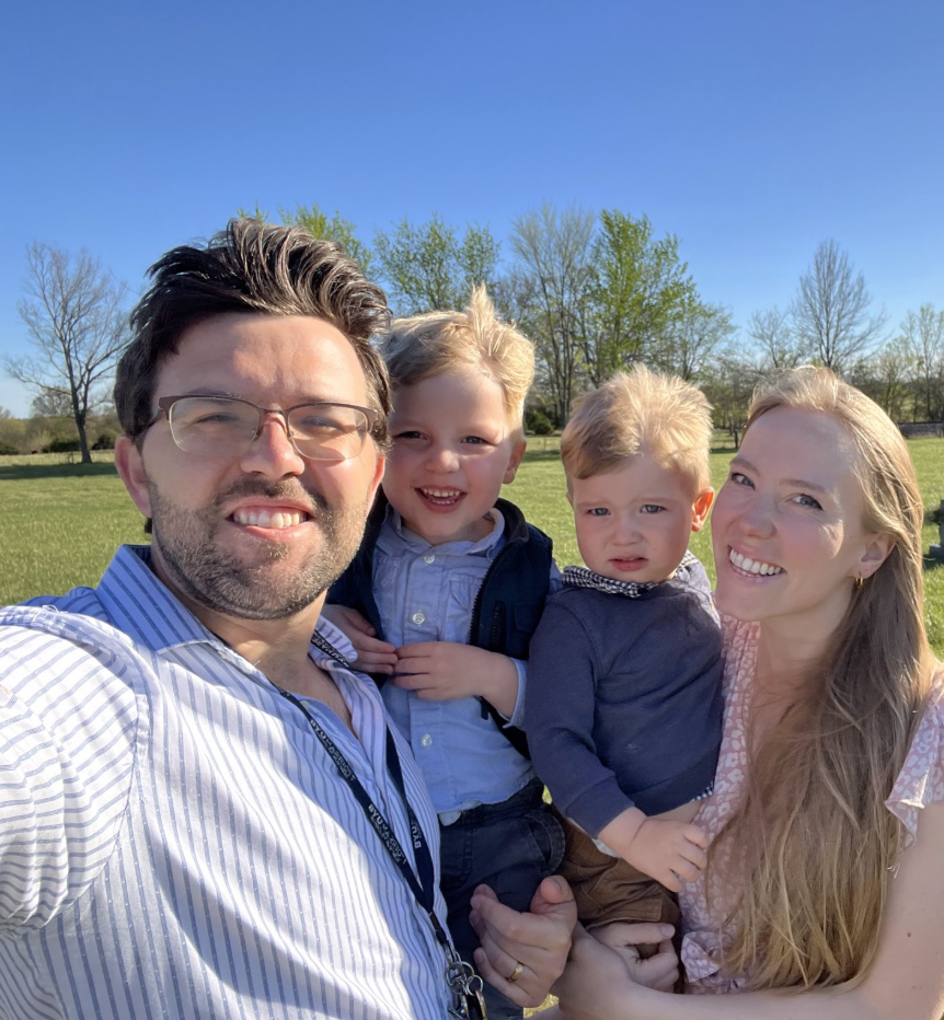 Family standing with an inflatable bounce house at an outdoor event